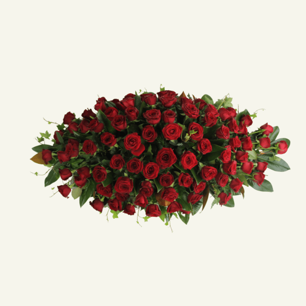 Impressive red rose casket spray cover accompanied with fresh foliage