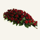 Side view of impressive red rose casket cover and foliage